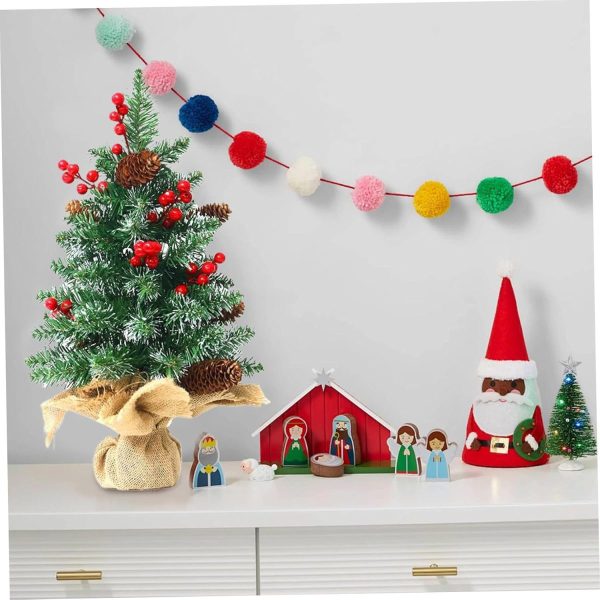 Miniature Christmas tree with red berries and pinecones